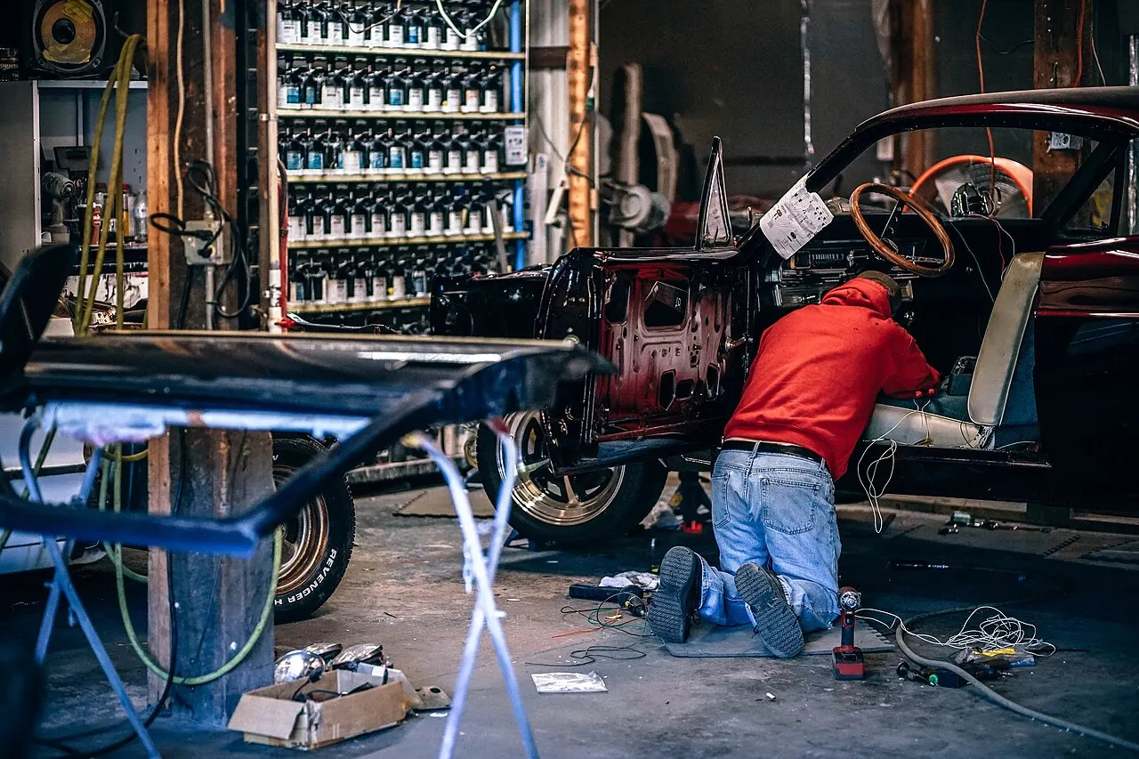 Technician working on a vehicle in a repair workshop